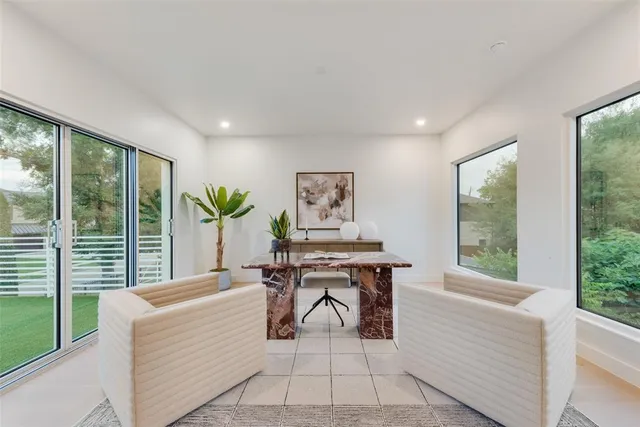 a living room with furniture and large windows