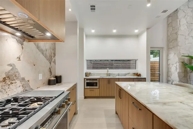 a kitchen with stainless steel appliances granite countertop a stove and a sink