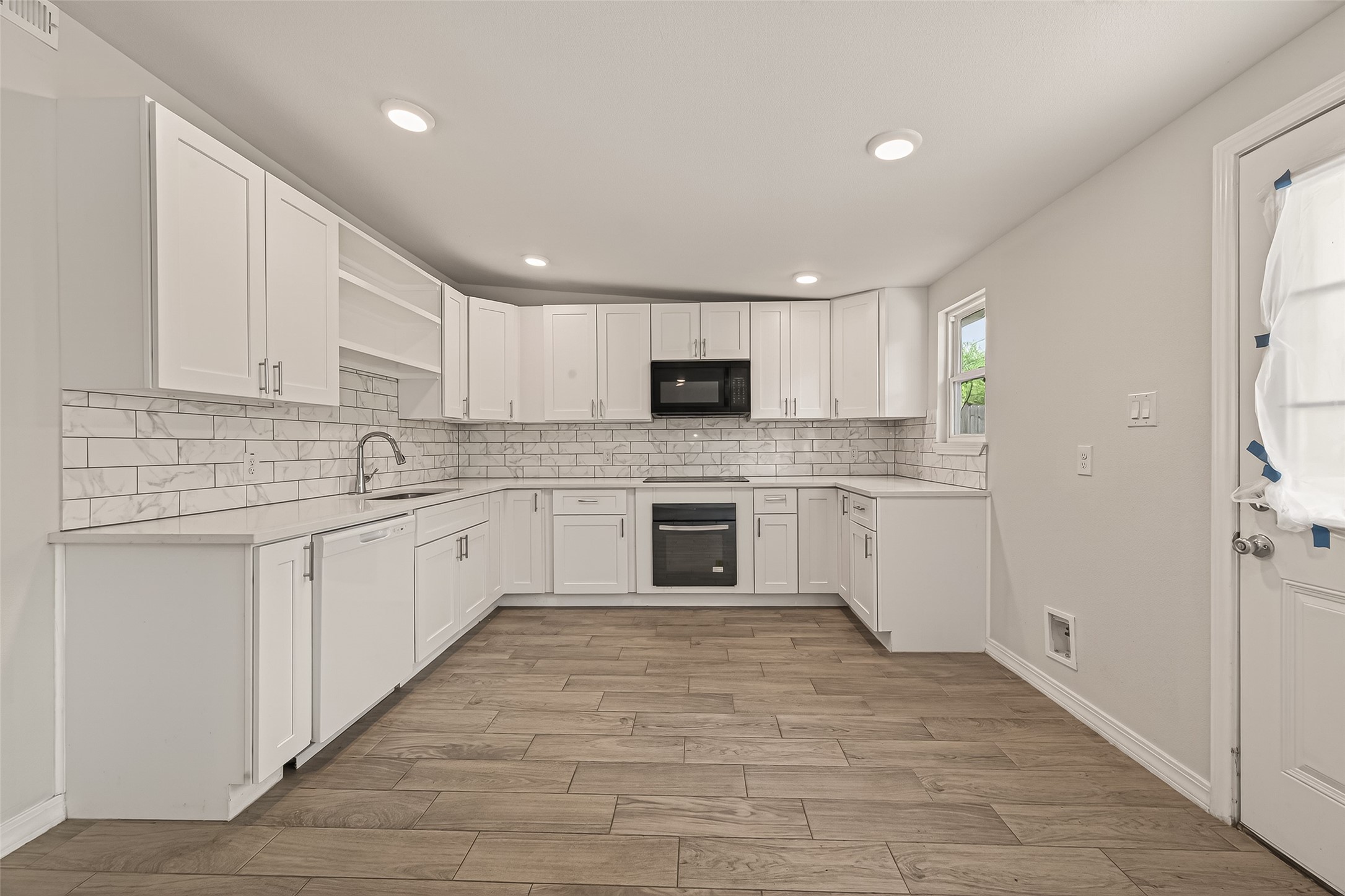 3710 Daphne Street Houston, TX 77021 - Photo 11 of 39 a large white kitchen with cabinets appliances a sink and a window