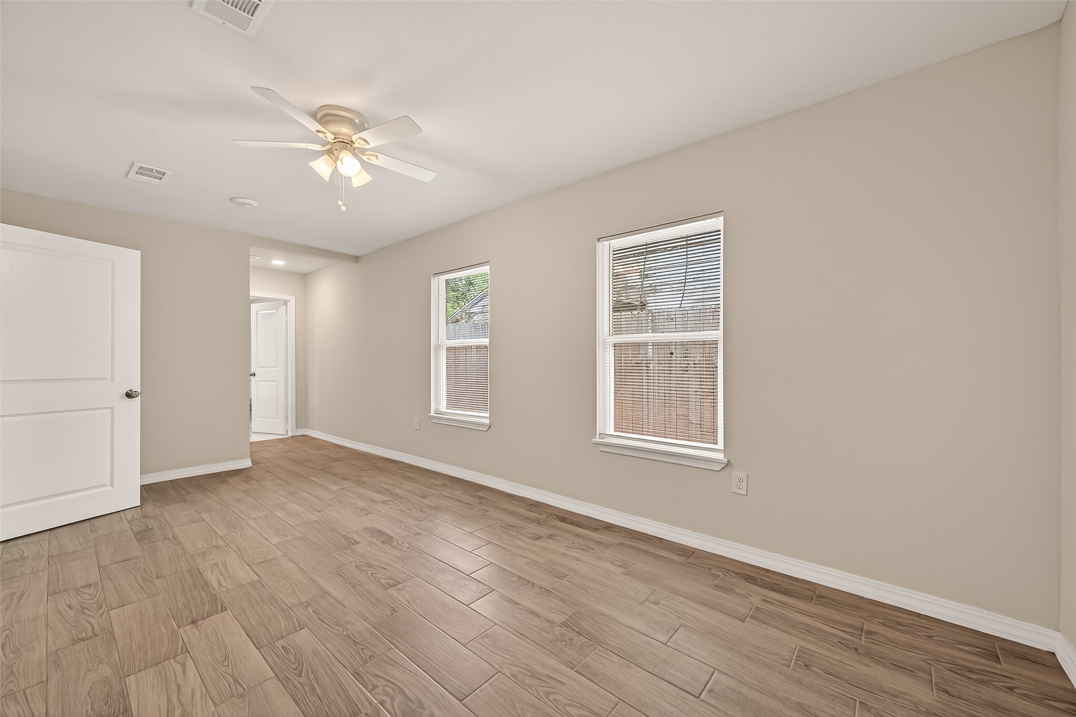 3710 Daphne Street Houston, TX 77021 - Photo 26 of 39 an empty room with wooden floor chandelier fan and windows