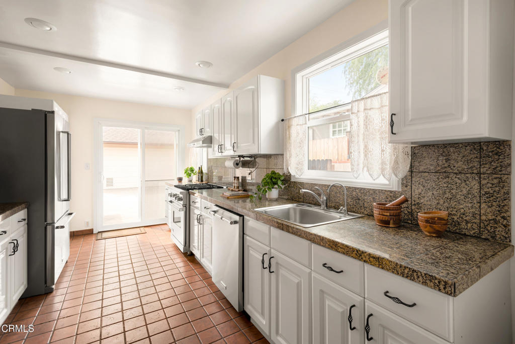 1587 North Harding Avenue Pasadena, CA 91104 - Photo 15 of 37 a kitchen with a sink a counter top space cabinets stainless steel appliances and a window