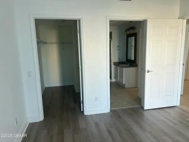 an entryway with wooden floor and cabinet