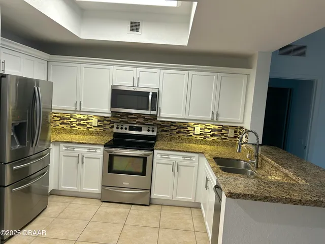 a kitchen with kitchen island granite countertop stainless steel appliances and cabinets