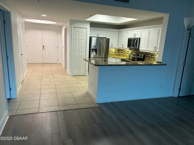 a kitchen with stainless steel appliances granite countertop a refrigerator and a stove top oven