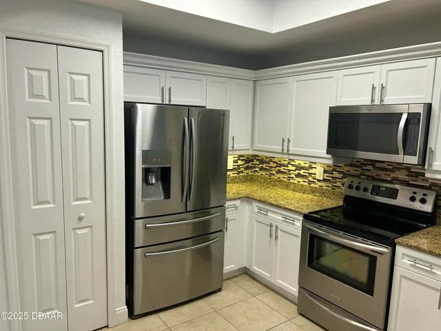a kitchen with stainless steel appliances and refrigerator