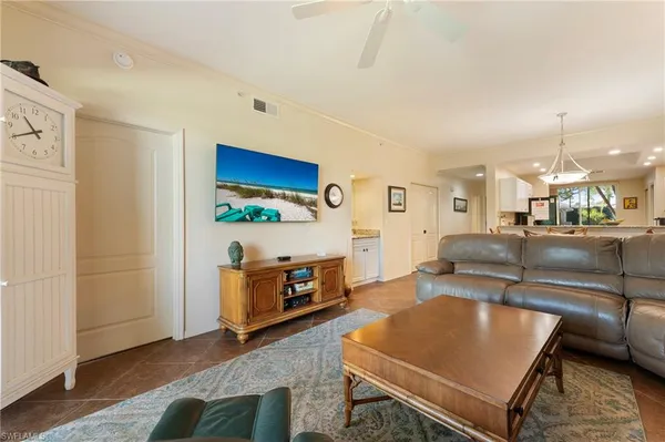 a living room with furniture a ceiling fan and a bookshelf