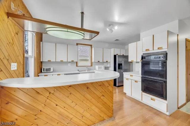 a large kitchen with stainless steel appliances kitchen island granite countertop a refrigerator and a stove top oven