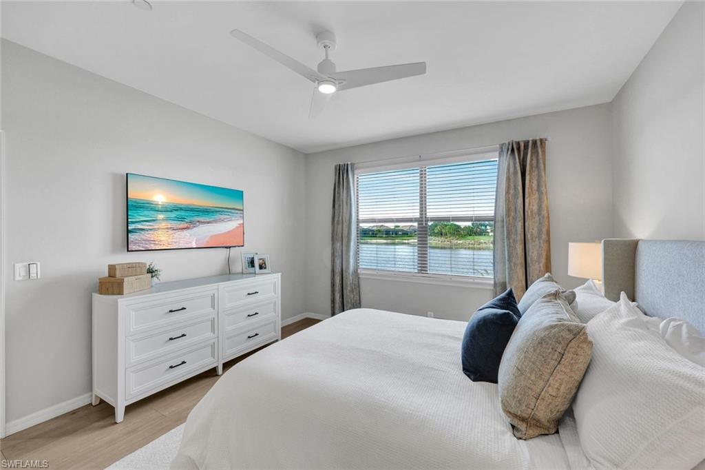9373 Pocida Court, Unit 104 Naples, FL 34119 - Photo 12 of 24 a bedroom with a bed and a flat screen tv