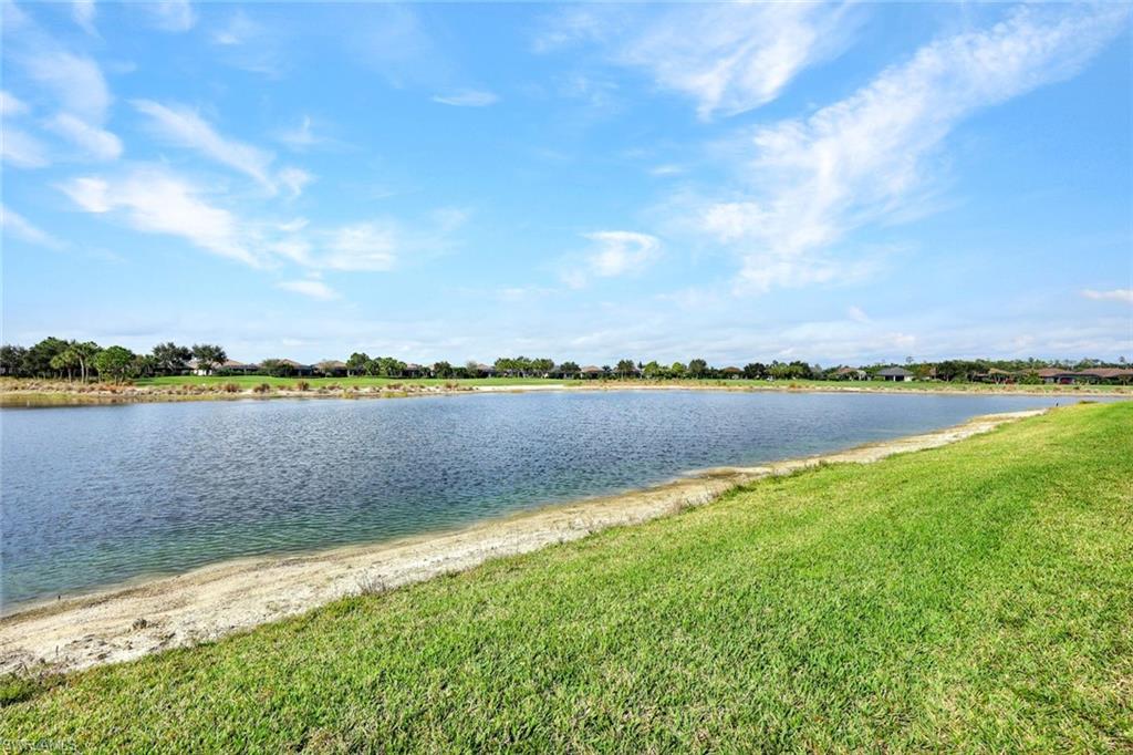 9373 Pocida Court, Unit 104 Naples, FL 34119 - Photo 20 of 24 a view of a lake with houses in the back