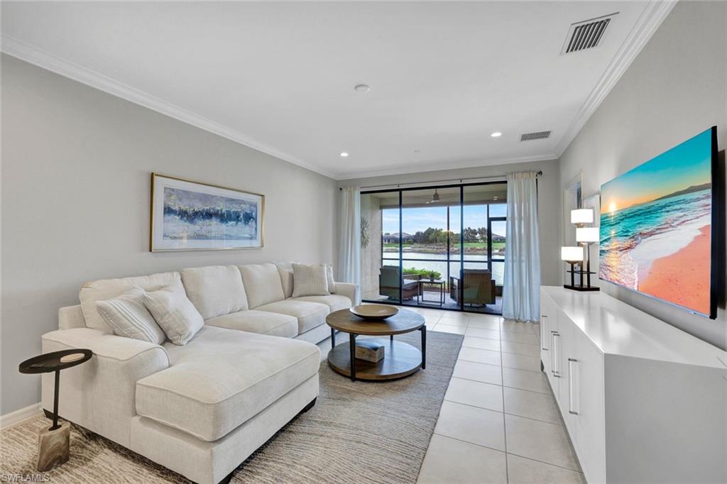 9373 Pocida Court, Unit 104 Naples, FL 34119 - Photo 4 of 24 a living room with furniture and a flat screen tv