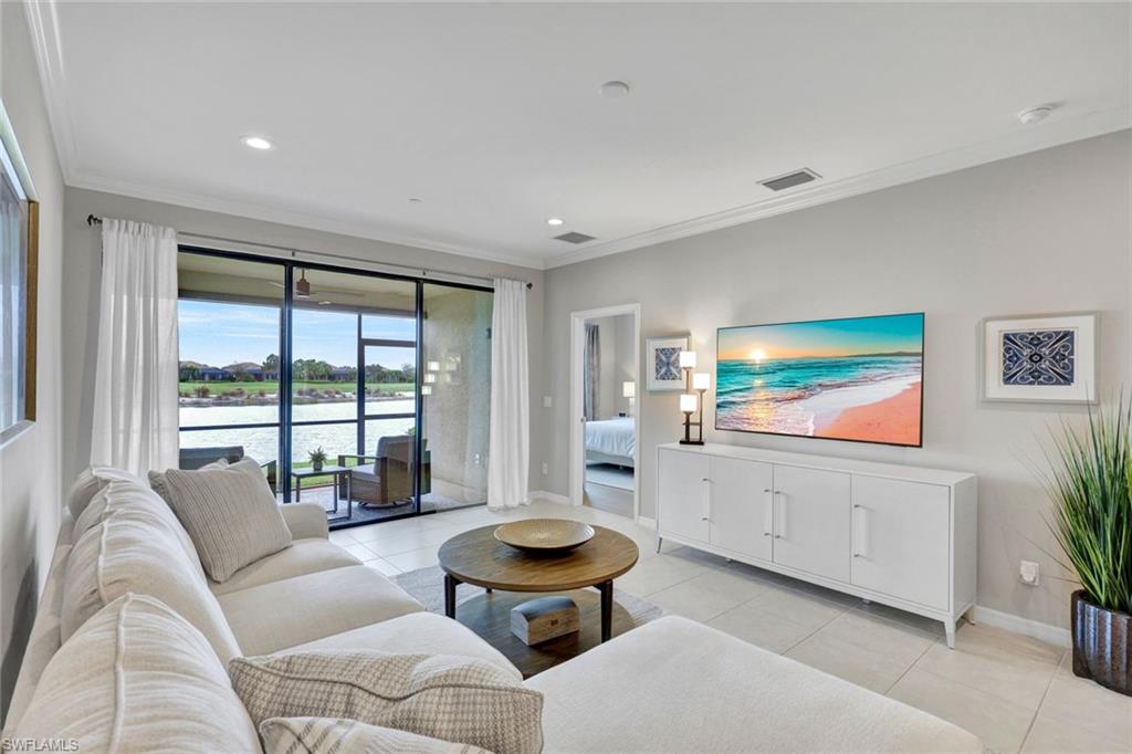 9373 Pocida Court, Unit 104 Naples, FL 34119 - Photo 5 of 24 a living room with furniture and a flat screen tv