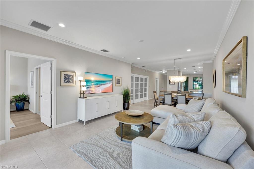 9373 Pocida Court, Unit 104 Naples, FL 34119 - Photo 6 of 24 a living room with furniture and a flat screen tv