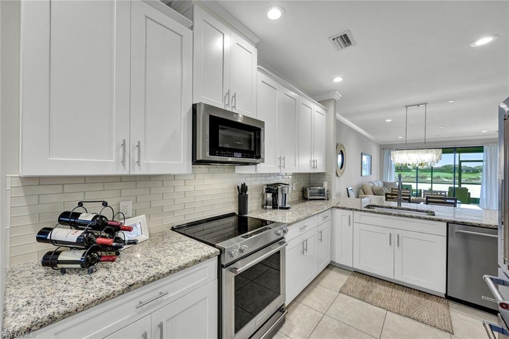 9373 Pocida Court, Unit 104 Naples, FL 34119 - Photo 7 of 24 a kitchen with sink a microwave and cabinets