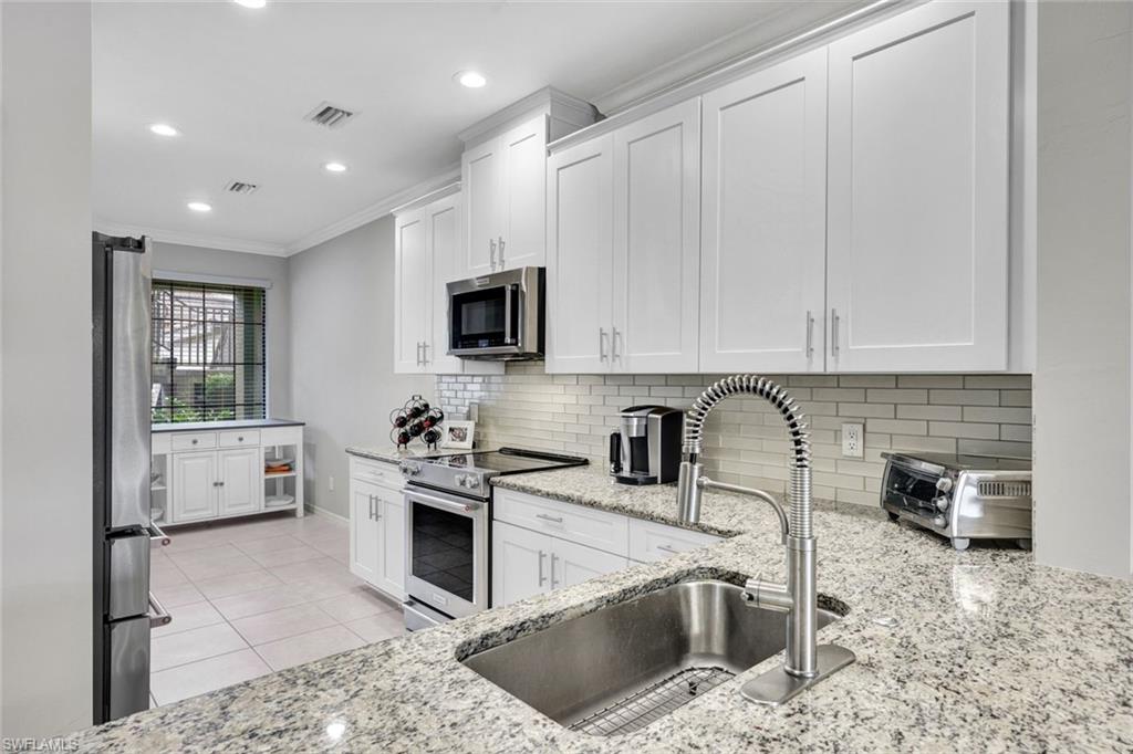 9373 Pocida Court, Unit 104 Naples, FL 34119 - Photo 8 of 24 a kitchen with a sink stove and cabinets