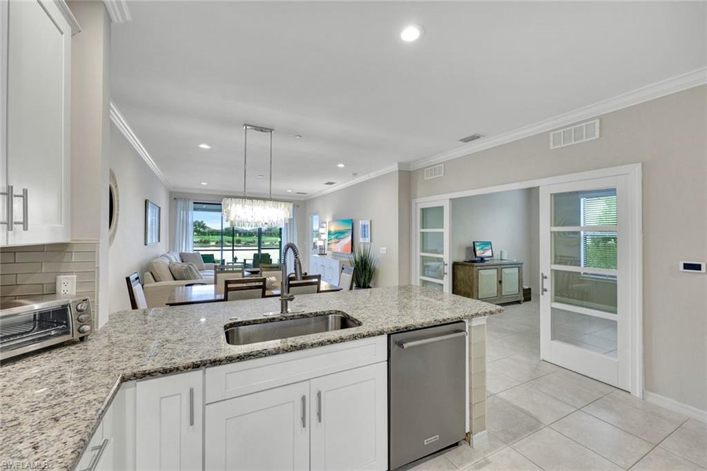 9373 Pocida Court, Unit 104 Naples, FL 34119 - Photo 9 of 24 a kitchen with granite countertop a sink and a counter top space