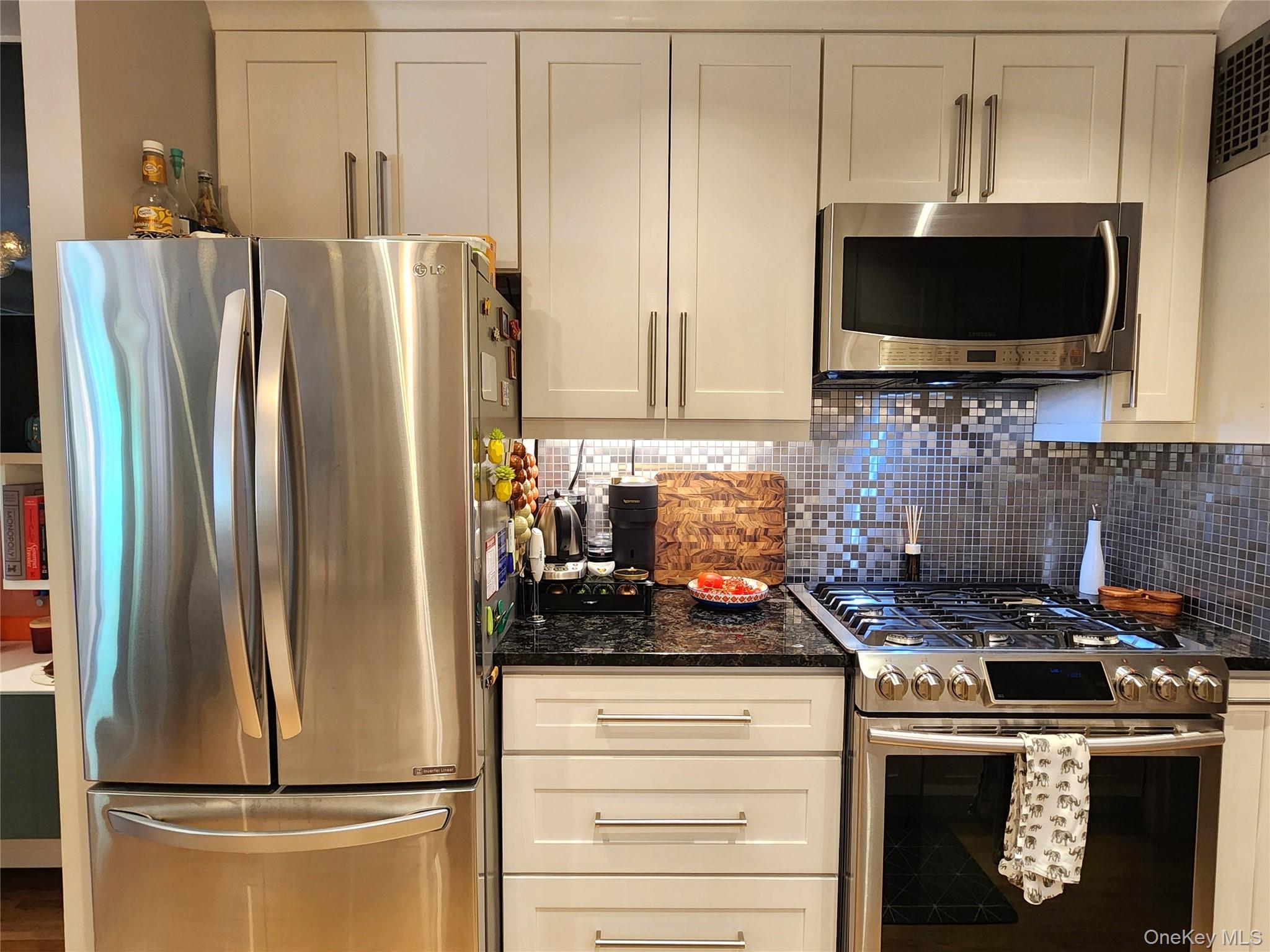 25 Park Place, Unit 3R Great Neck, NY 11021 - Photo 2 of 18 a kitchen with a refrigerator and a stove top oven
