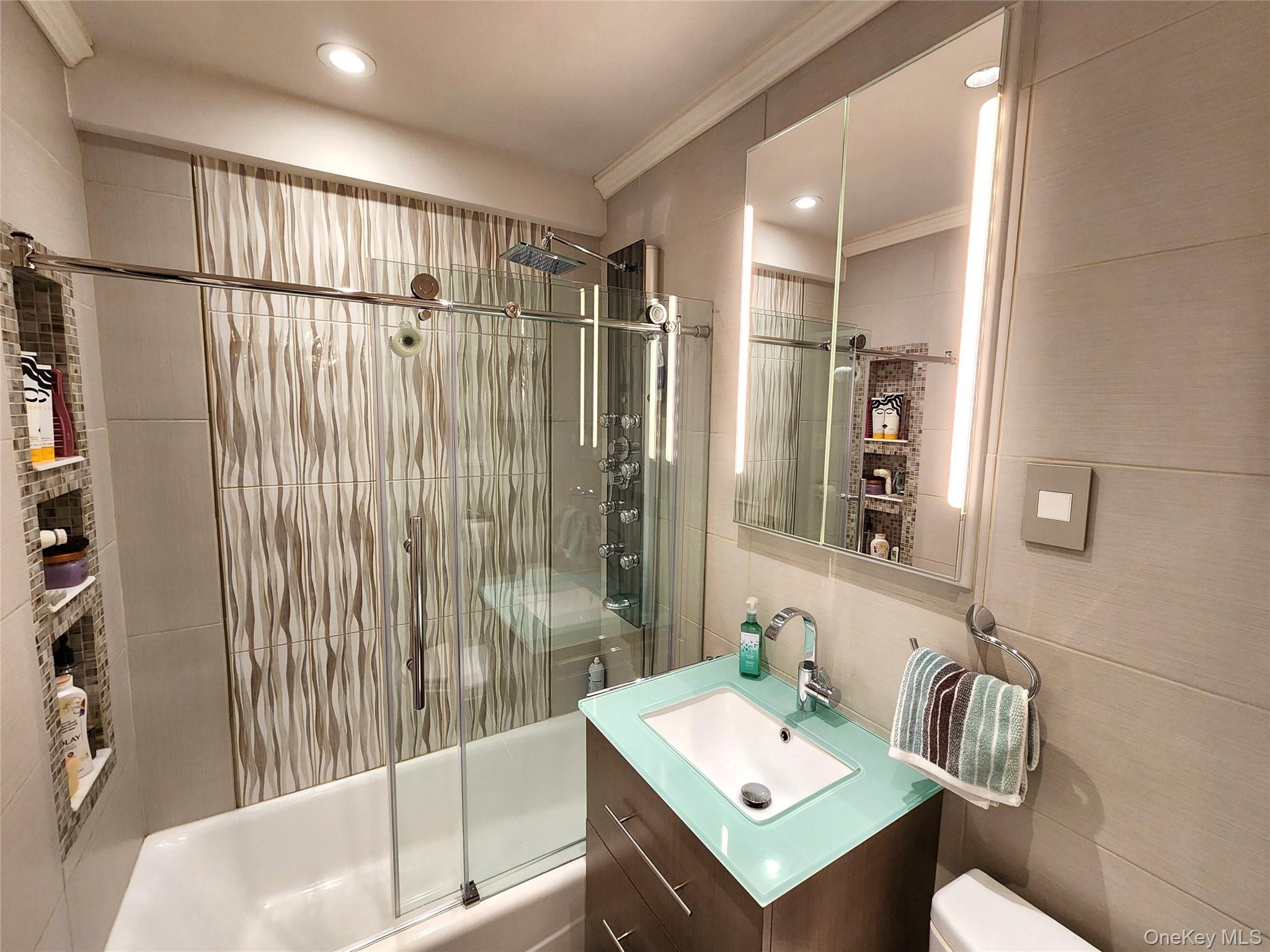 25 Park Place, Unit 3R Great Neck, NY 11021 - Photo 4 of 18 a bathroom with a sink toilet and shower