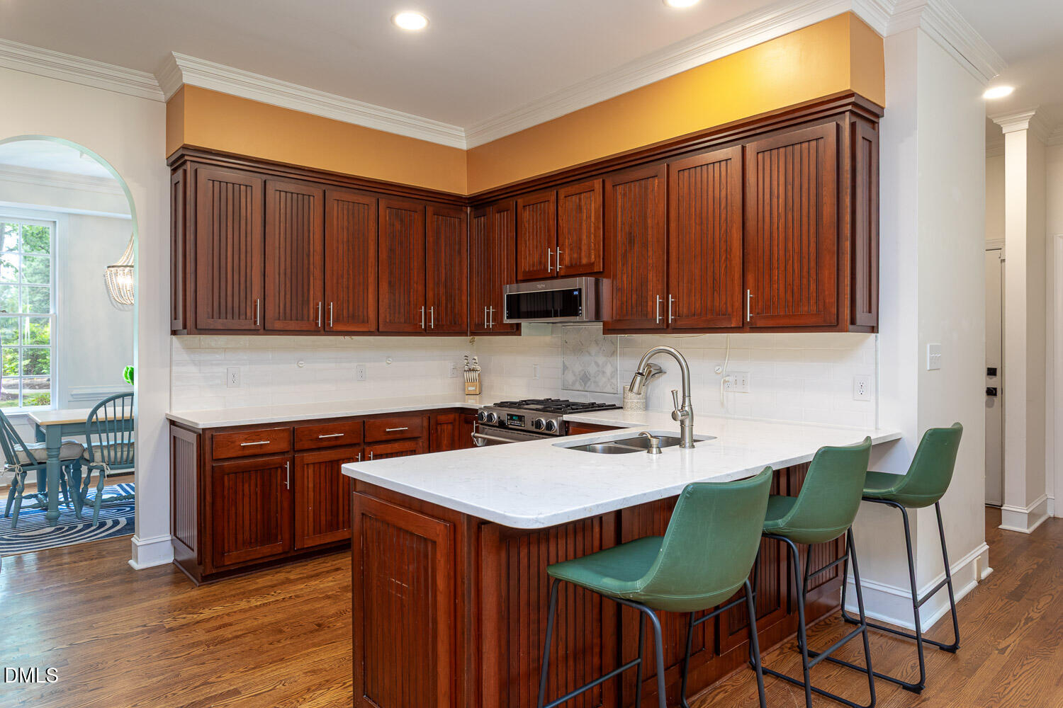 8509 Towneley Place Raleigh, NC 27615 - Photo 12 of 36 a kitchen with stainless steel appliances granite countertop a table chairs in it and wooden floors