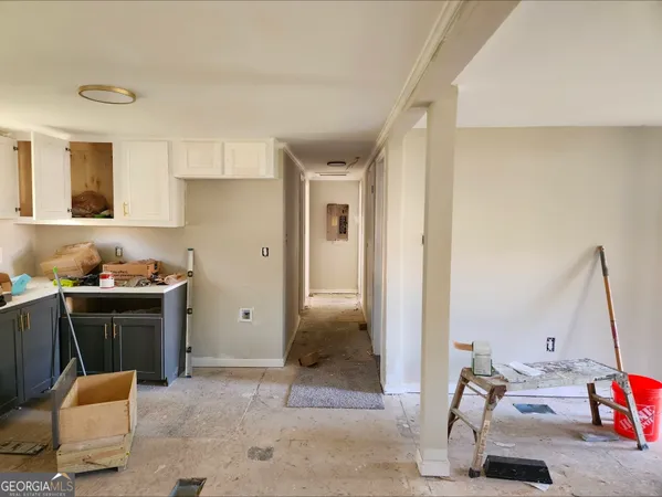 a view of kitchen with stainless steel appliances kitchen island granite countertop dining table chairs and a refrigerator