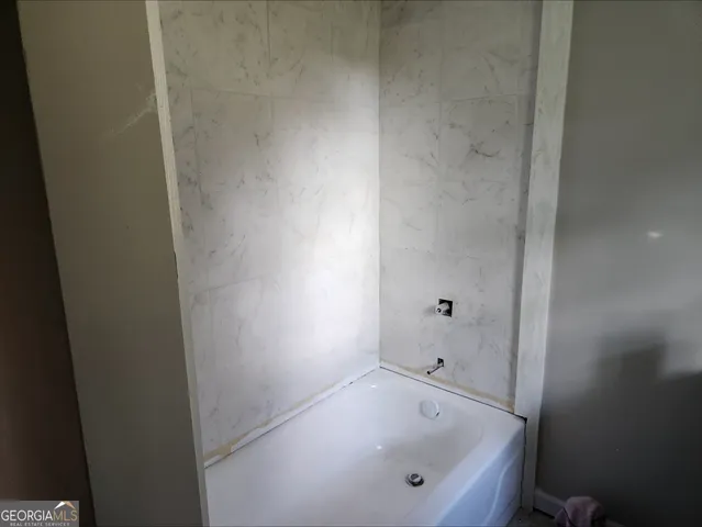 a bathroom with a tub and shower