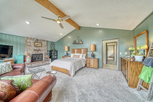 a spacious bedroom with a large bed a flat tv screen and a dresser