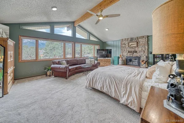 a spacious bedroom with a bed a couch and a large window