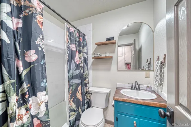 a bathroom with a granite countertop sink and a mirror with toilet