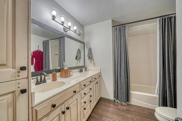 a bathroom with a double vanity sink mirror and bathtub