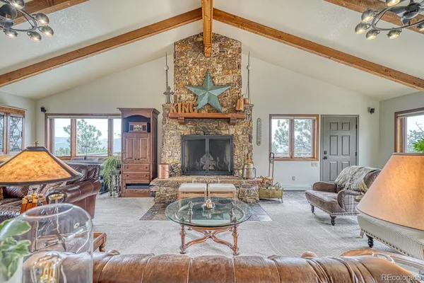 a living room with furniture a fireplace and a chandelier