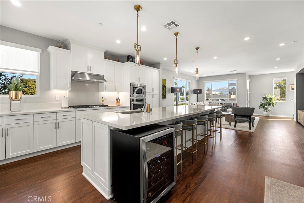 147 Schick Irvine, CA 92614 - Photo 18 of 35 a kitchen with stainless steel appliances granite countertop a stove a sink dishwasher a refrigerator and white cabinets with wooden floor