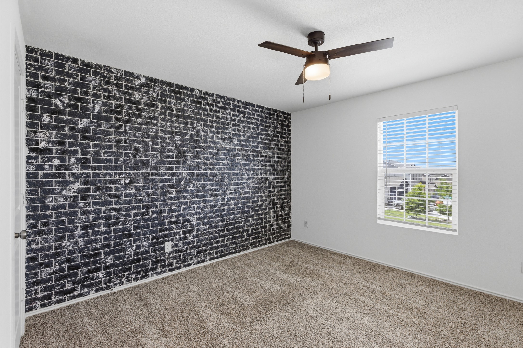 116 Night Riders Way Jarrell, TX 76537 - Photo 27 of 40 Accent wall featuring black brick-style finish, complemented by neutral wall paint