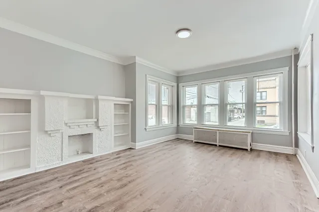 an empty room with a fireplace and windows