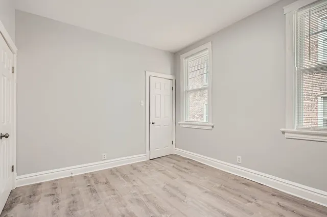 an empty room with windows and closet