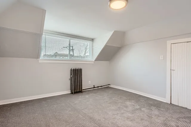 an empty room with wooden floor and window