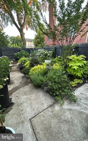 a garden with lots of trees and flowers in front of it