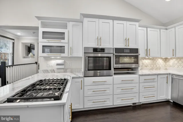 a kitchen with white cabinets and appliances