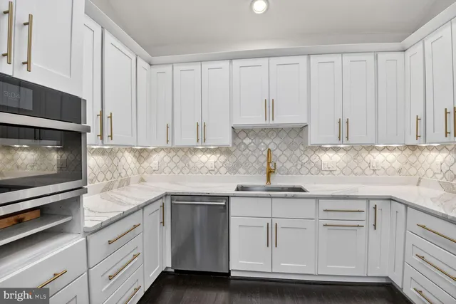 a kitchen with white cabinets and white appliances