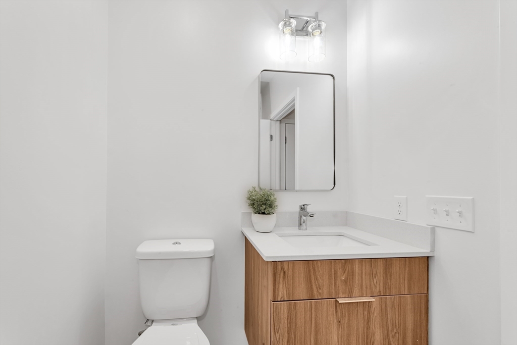 3992 Washington Street, Unit 302 Boston, MA 02131 - Photo 22 of 29 a bathroom with a sink a toilet and mirror