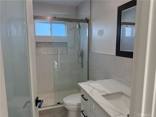 a bathroom with a granite countertop sink toilet and shower