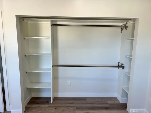 a view of walk in closet with empty racks