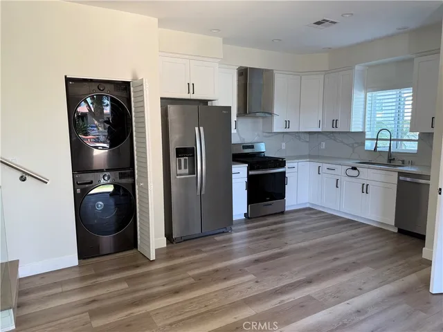 a kitchen with a refrigerator and a stove top oven