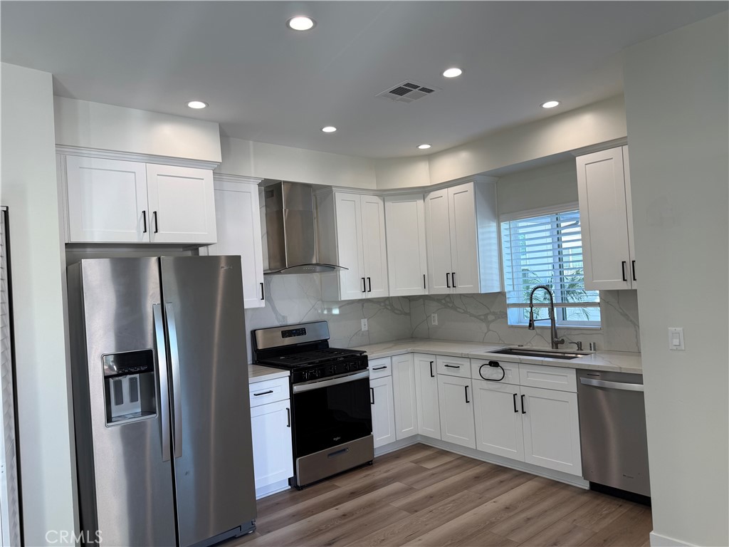 9585 Woodale Avenue Arleta, CA 91331 - Photo 5 of 21 a kitchen with a refrigerator and a sink