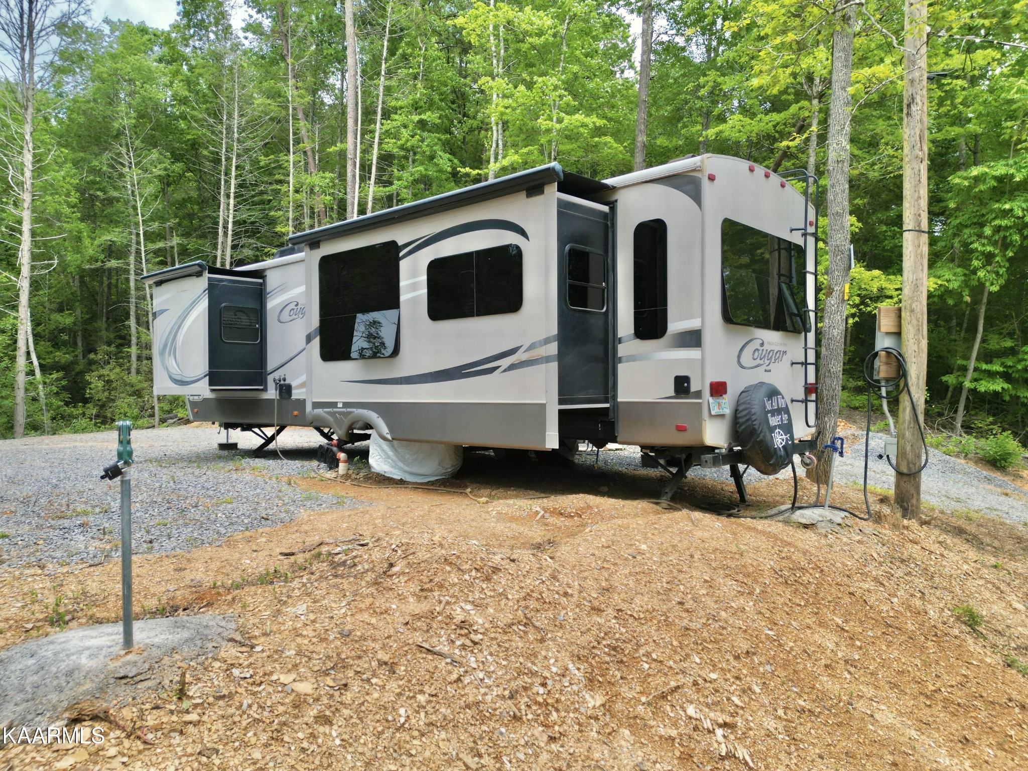 4965 Jones Cove Road Cosby, TN 37722 - Photo 11 of 50 a view of a white house with a yard and lawn chairs
