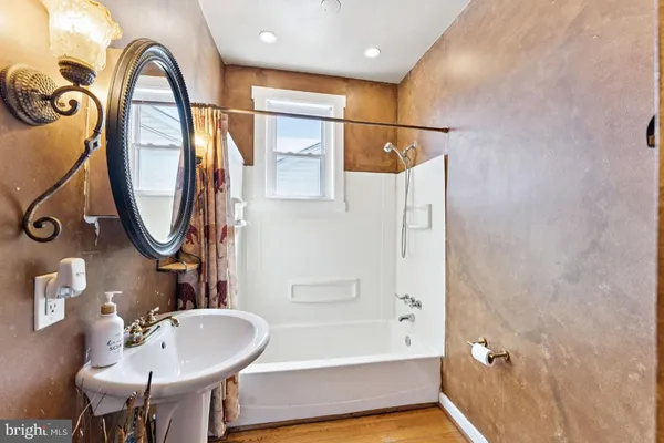 a bathroom with a sink a mirror and a bathtub