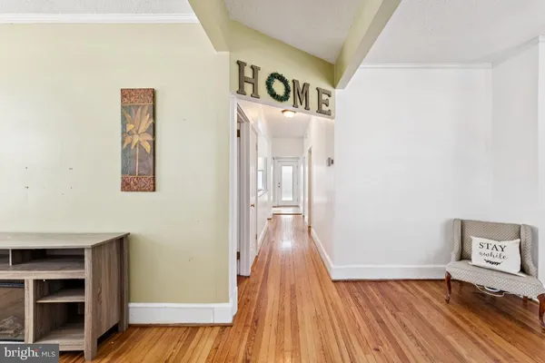 a view of a hallway with wooden floor and closet