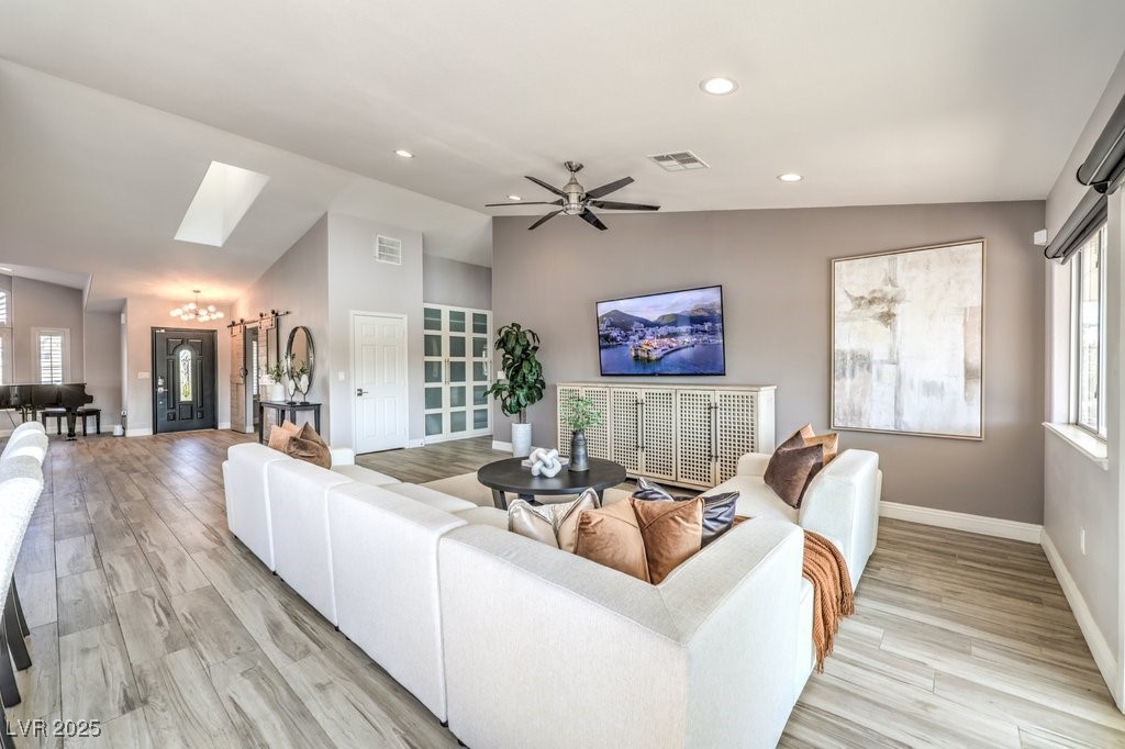 2432 Ocean Front Drive Las Vegas, NV 89128 - Photo 13 of 53 Living room with a chandelier, recessed lighting, ceiling fan, light wood-style floors, and a skylight