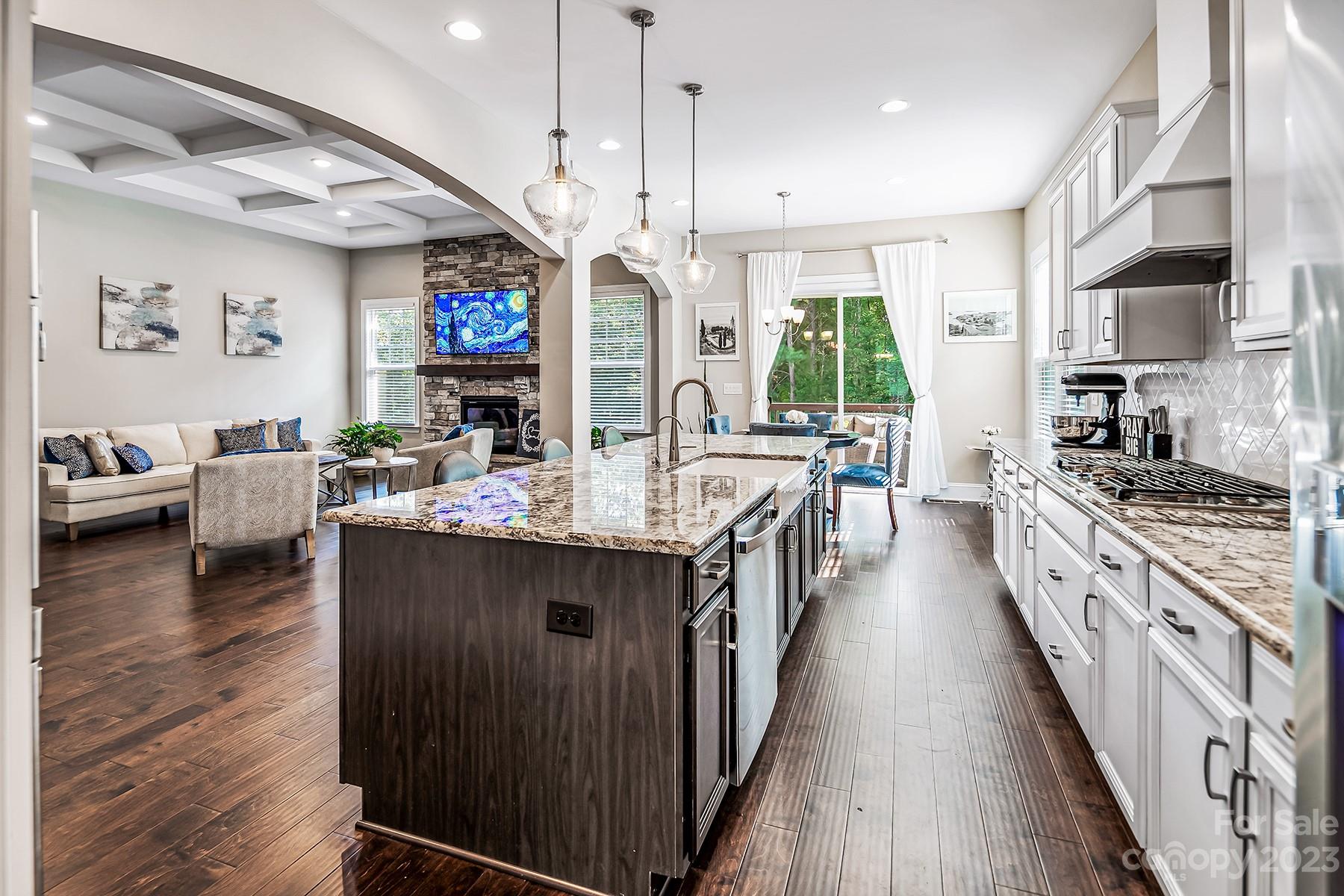 1004 Princessa Drive Wesley Chapel, NC 28104 - Photo 11 of 40 a kitchen with stainless steel appliances granite countertop a stove top oven a sink dishwasher and a dining table with wooden floor