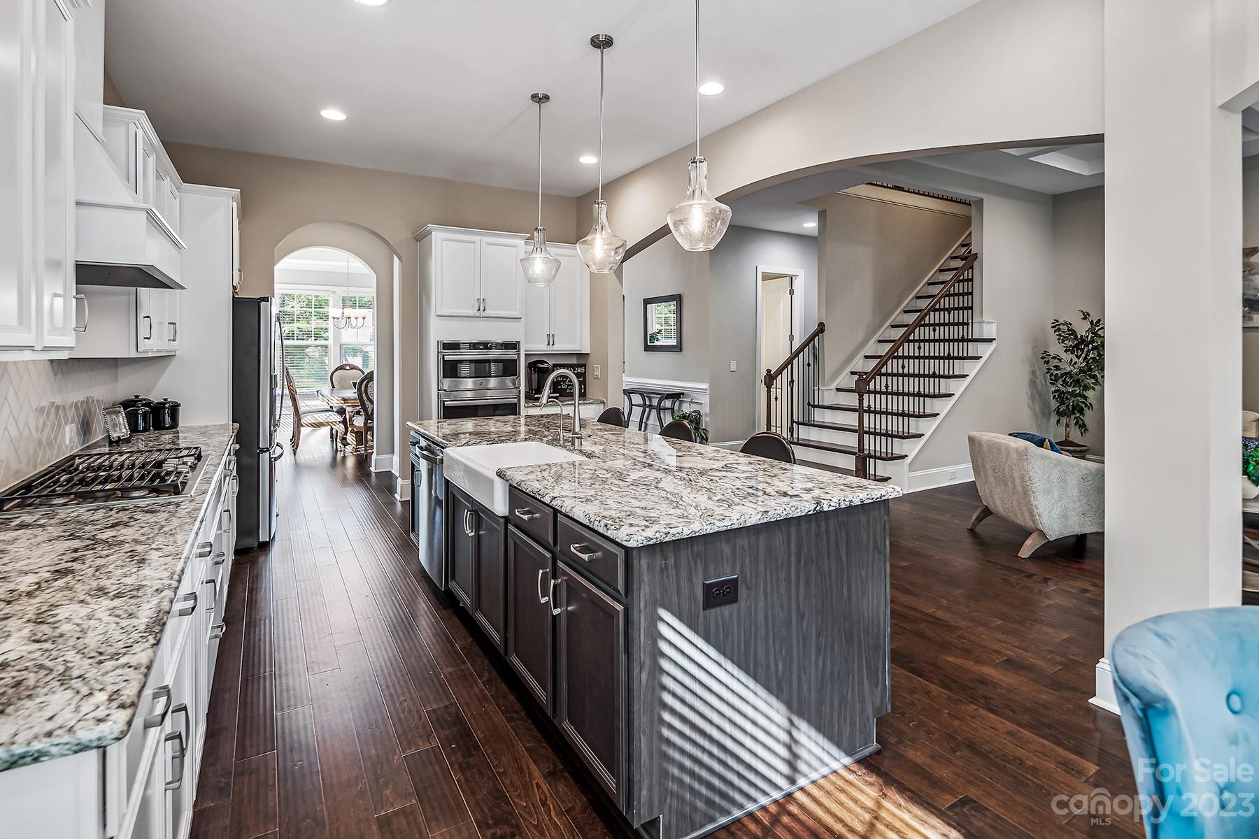 1004 Princessa Drive Wesley Chapel, NC 28104 - Photo 12 of 40 a kitchen with stainless steel appliances granite countertop lots of counter top space and wooden floor