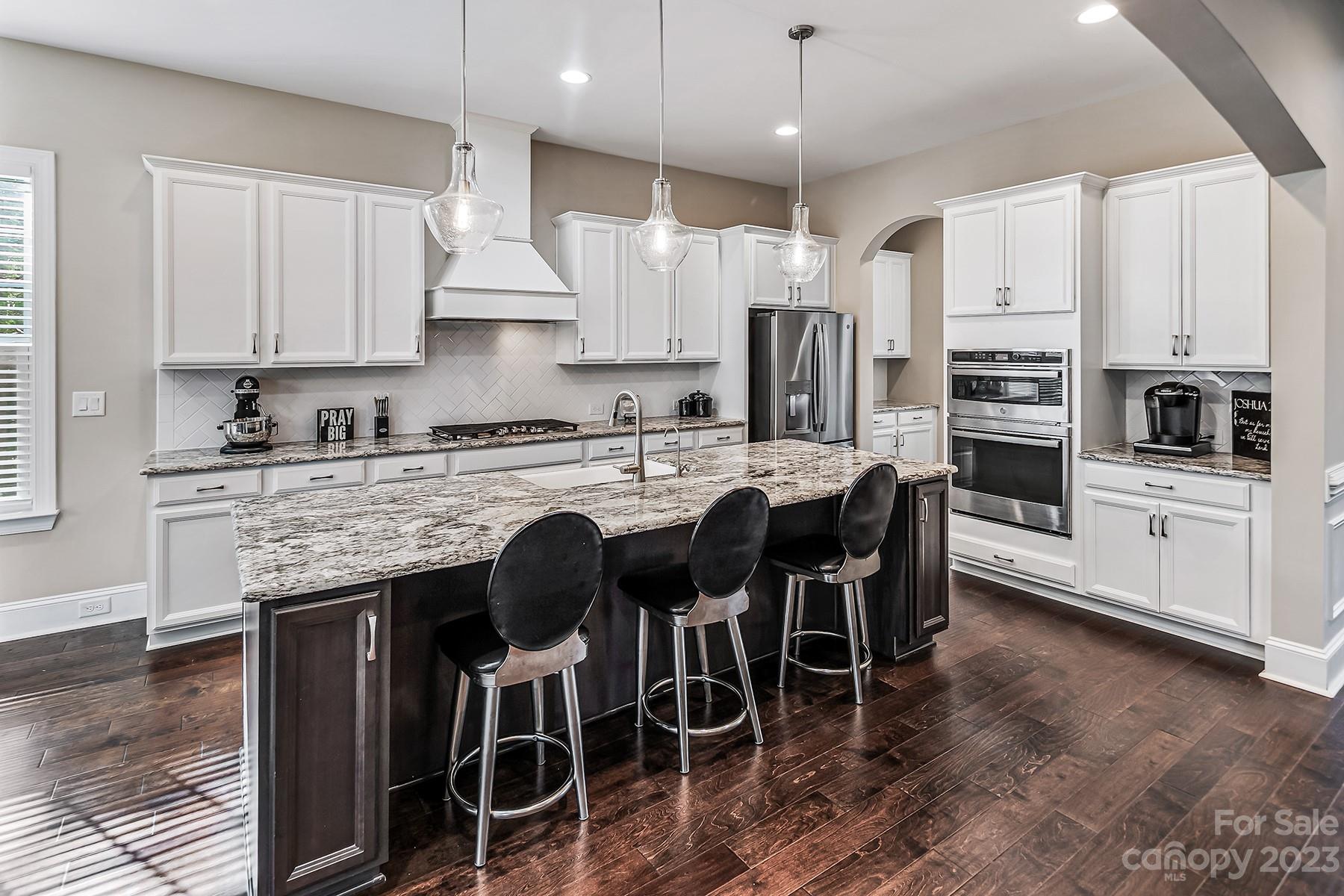 1004 Princessa Drive Wesley Chapel, NC 28104 - Photo 13 of 40 a kitchen with stainless steel appliances granite countertop a table chairs sink refrigerator and microwave
