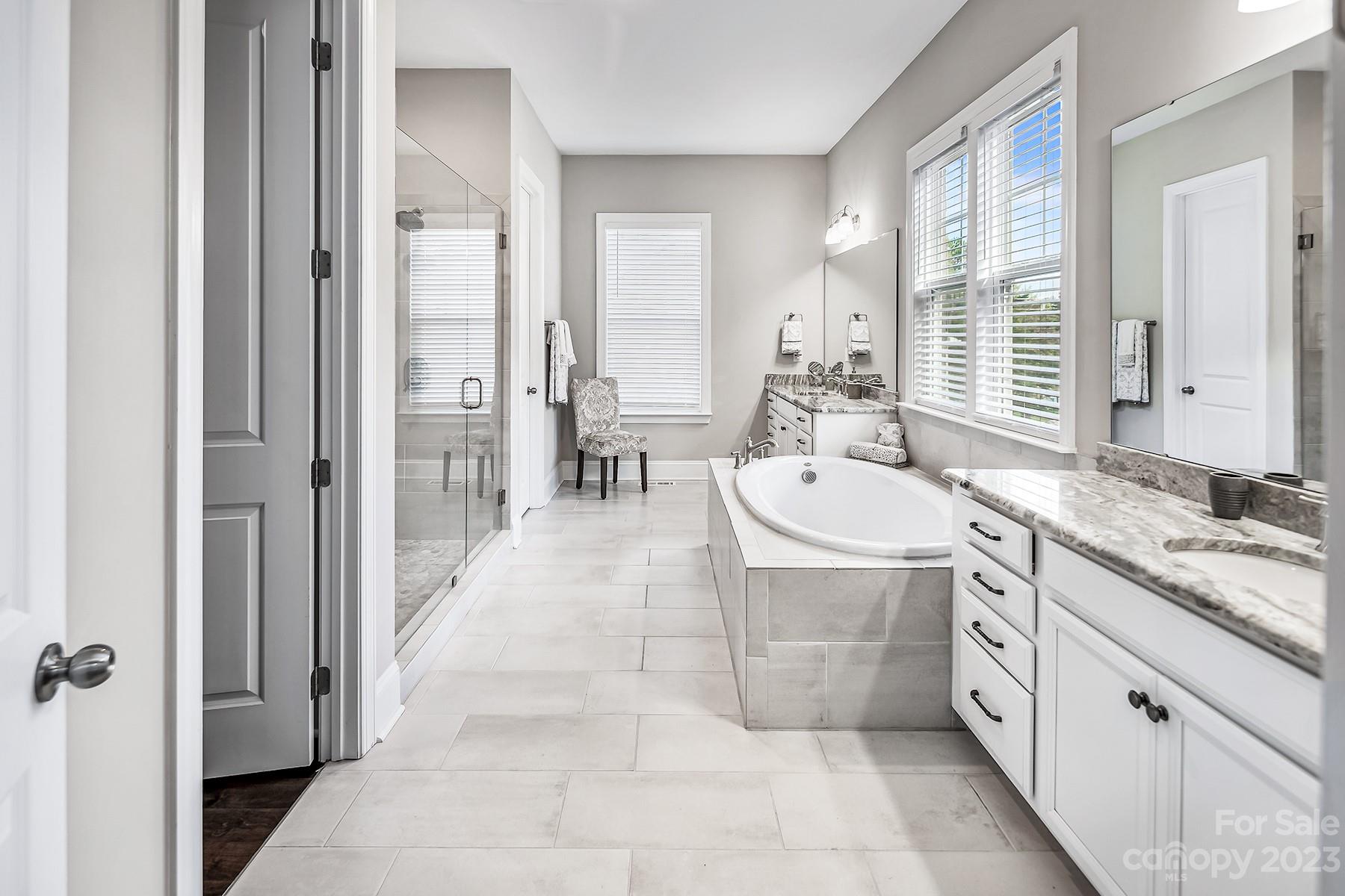 1004 Princessa Drive Wesley Chapel, NC 28104 - Photo 23 of 40 a spacious bathroom with a double vanity sink a mirror and a shower